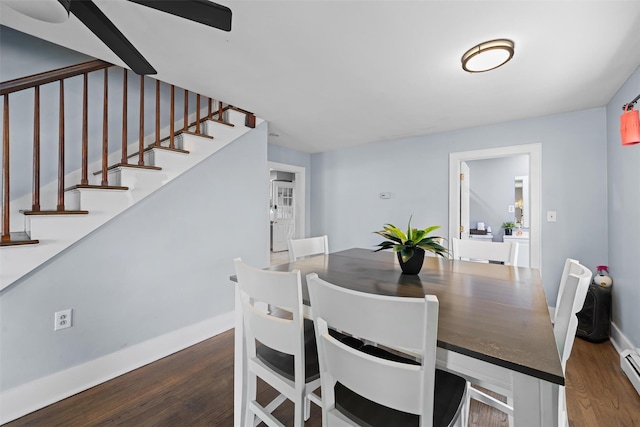 dining room with ceiling fan, wood finished floors, baseboards, a baseboard radiator, and stairs