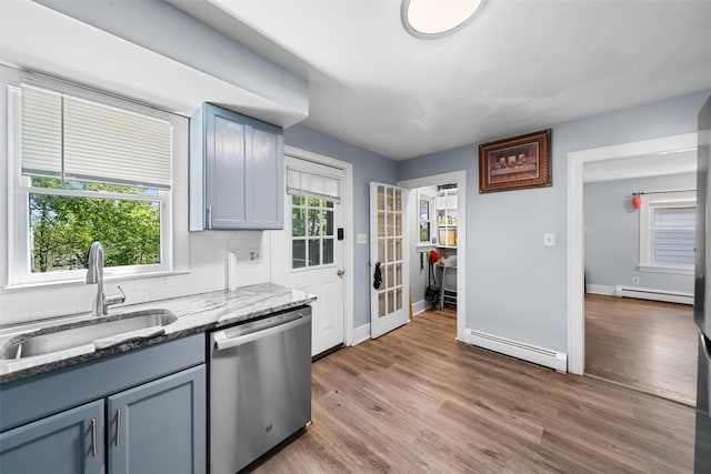 kitchen featuring a sink, baseboard heating, backsplash, and dishwasher