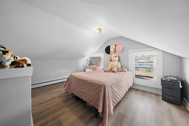 bedroom featuring wood finished floors, a baseboard heating unit, and vaulted ceiling