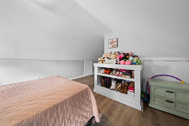 bedroom featuring wood finished floors and lofted ceiling