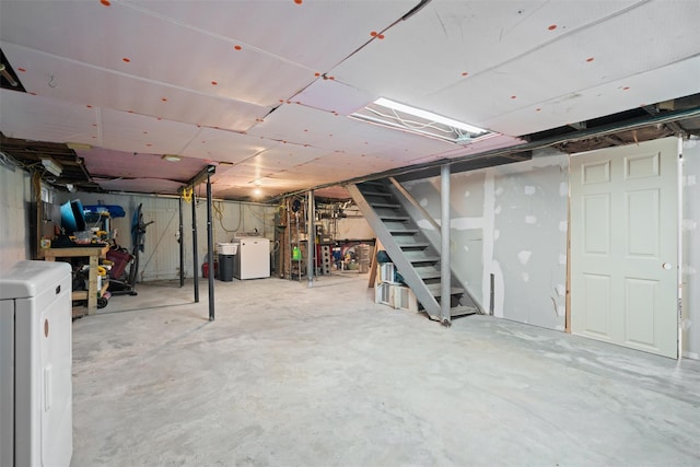 unfinished below grade area featuring washer / dryer and stairway