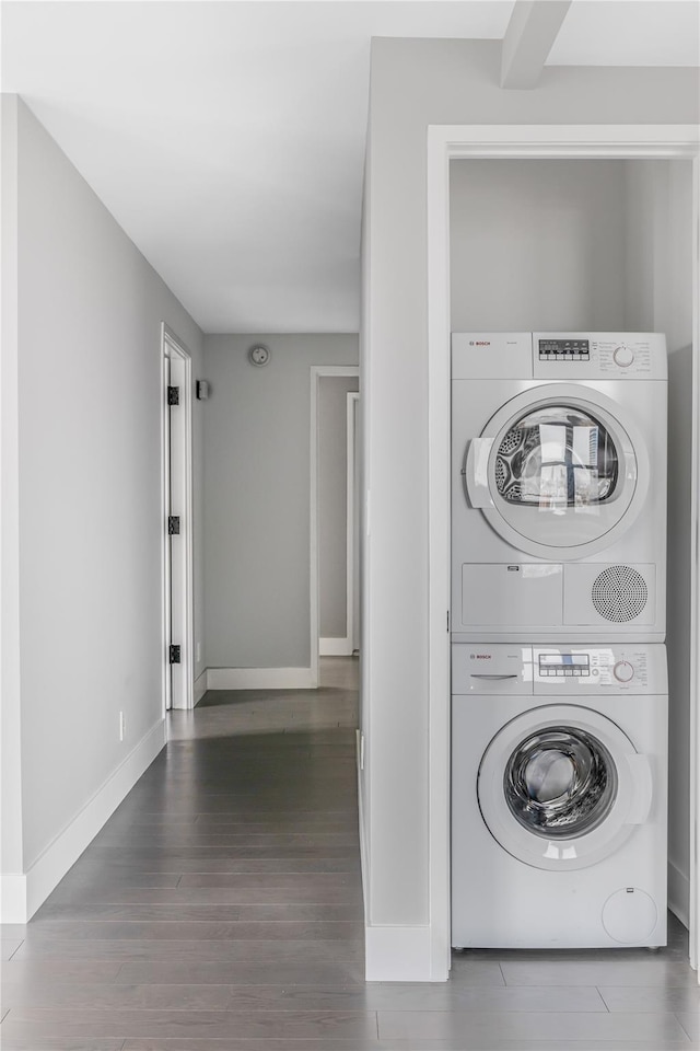 175 W 95th St Unit 27G, New York Manhattan, NY 10025 - clothes washing area featuring stacked washer and clothes dryer, wood finished floors, and baseboards