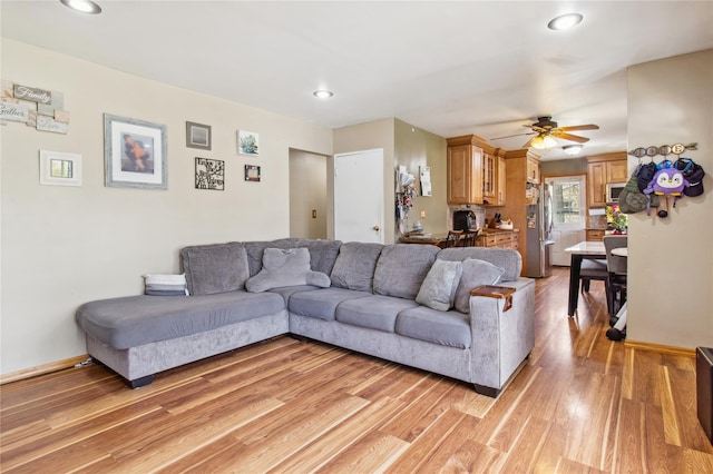living room featuring recessed lighting, a ceiling fan, light wood-style flooring, and baseboards