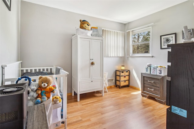 bedroom featuring visible vents, light wood finished floors, and baseboards