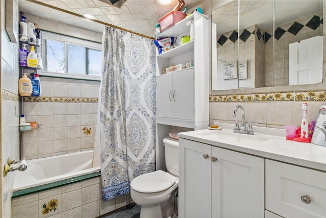 full bath featuring vanity, tiled shower / bath, toilet, and tile walls