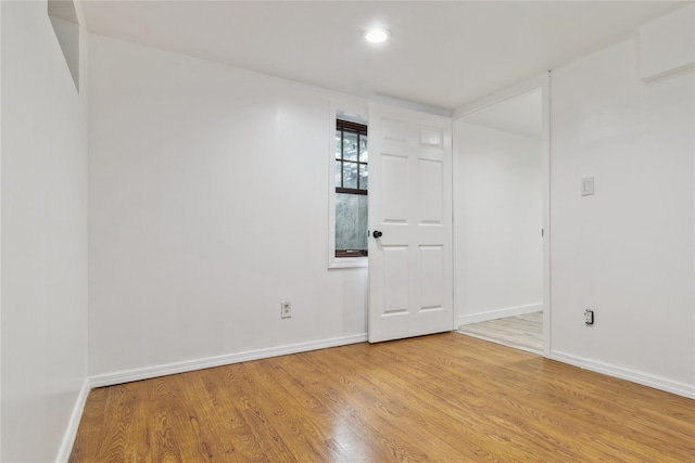 empty room featuring recessed lighting, baseboards, and light wood-type flooring