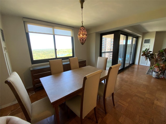 dining area with baseboards, a chandelier, and visible vents