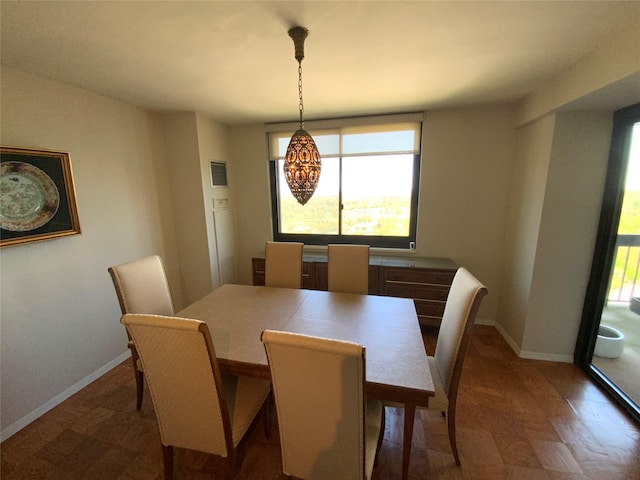 dining space with baseboards and dark floors