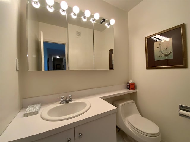 half bath featuring toilet, visible vents, and vanity