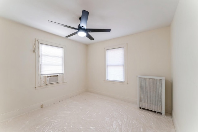 spare room with baseboards, a ceiling fan, and a wealth of natural light