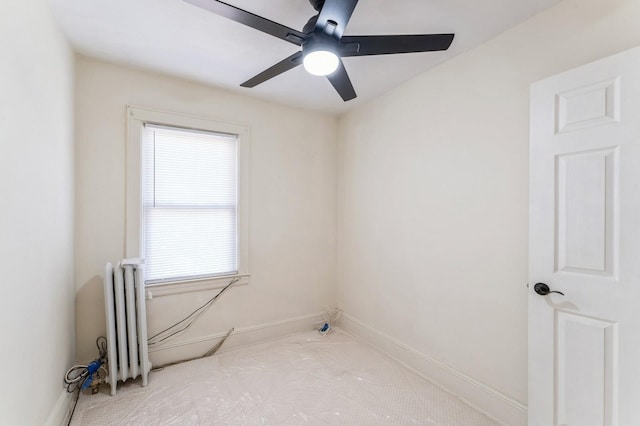 carpeted spare room with radiator heating unit, baseboards, and ceiling fan