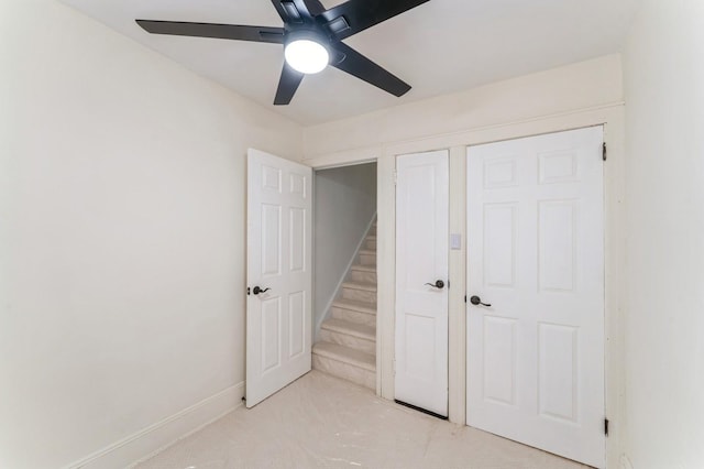 unfurnished bedroom featuring baseboards, a ceiling fan, and light colored carpet