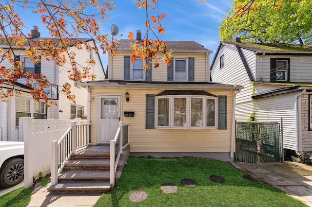 view of front of house featuring fence, a gate, and a front lawn