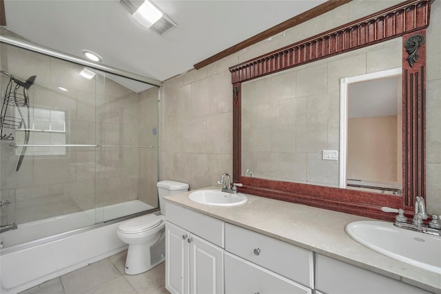 bathroom featuring tile patterned flooring, tile walls, a sink, and visible vents