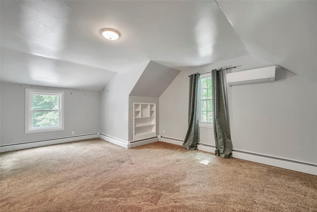additional living space featuring a wall unit AC, vaulted ceiling, baseboards, a baseboard radiator, and carpet