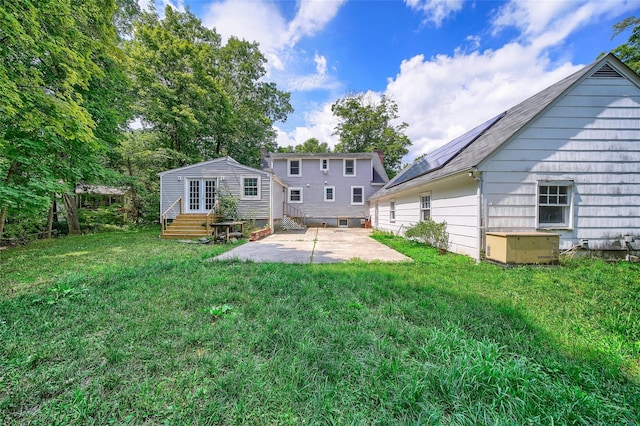 rear view of property with a patio, a yard, and french doors