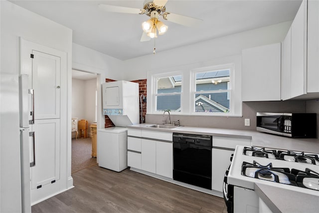 kitchen featuring gas range gas stove, a sink, stacked washing maching and dryer, stainless steel microwave, and black dishwasher