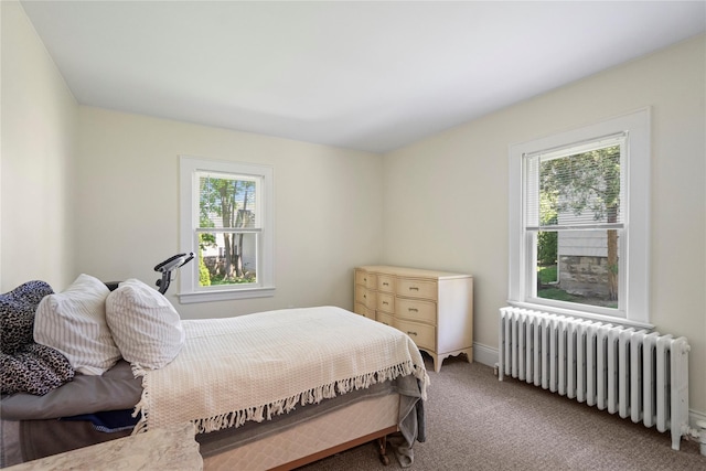 bedroom featuring radiator, baseboards, and light carpet