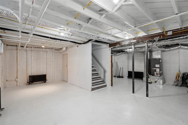 unfinished basement featuring heating unit, stairs, and radiator heating unit