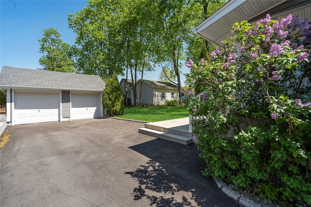 view of yard with a detached garage and an outdoor structure