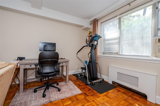 office space with baseboards and radiator