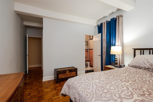 bedroom featuring baseboards and connected bathroom