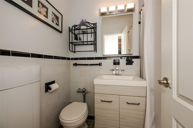 bathroom with tile walls, toilet, and vanity