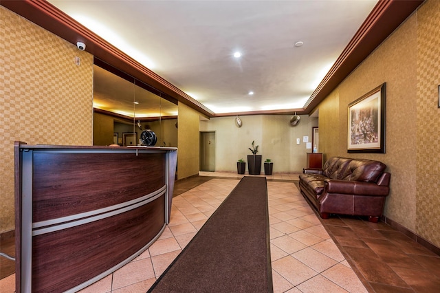reception with wallpapered walls, ornamental molding, and recessed lighting