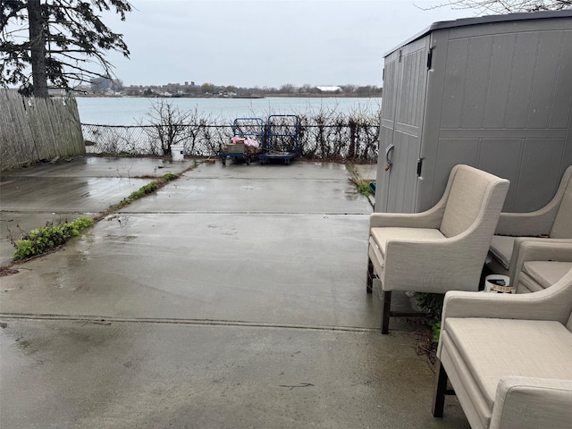view of patio / terrace with a water view and fence
