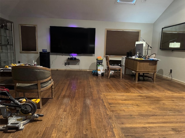 living area with baseboards, lofted ceiling, and wood finished floors