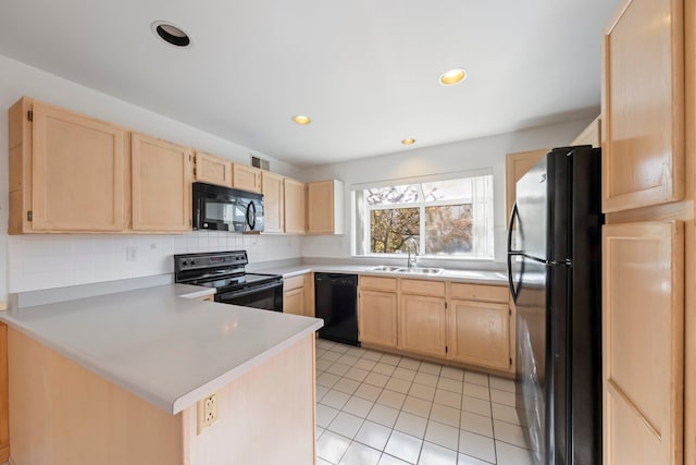 kitchen featuring backsplash, a sink, black appliances, a peninsula, and light brown cabinets