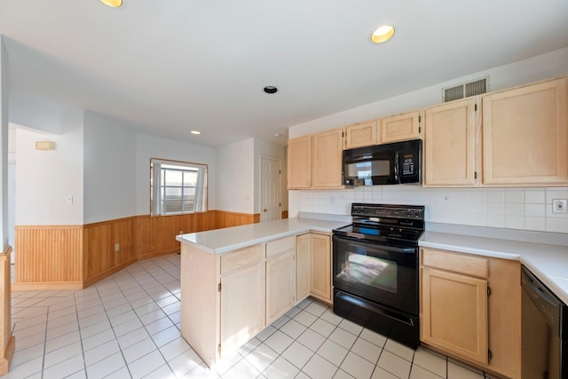 kitchen with light brown cabinetry, light countertops, a wainscoted wall, black appliances, and a peninsula
