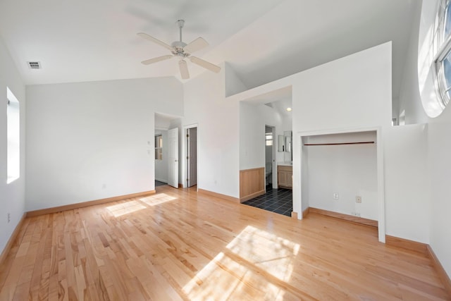 unfurnished bedroom with high vaulted ceiling, visible vents, multiple windows, and light wood-style floors