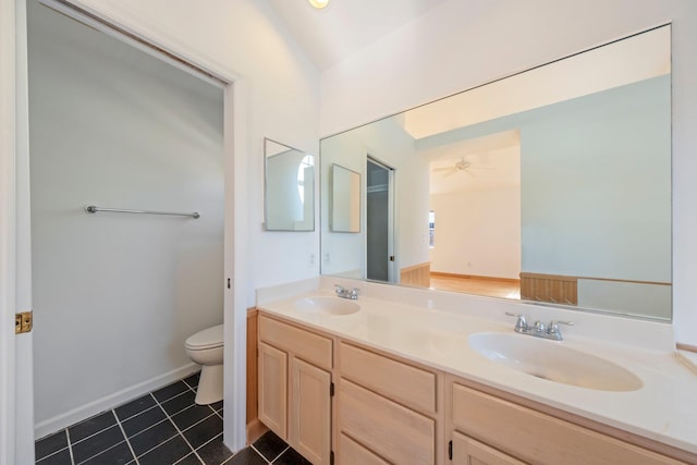 bathroom featuring double vanity, toilet, tile patterned floors, and a sink