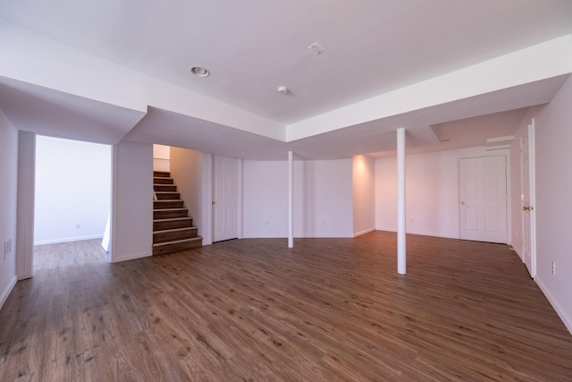 finished basement featuring baseboards, stairs, and wood finished floors
