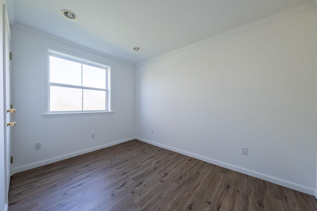 spare room featuring baseboards, ornamental molding, and wood finished floors
