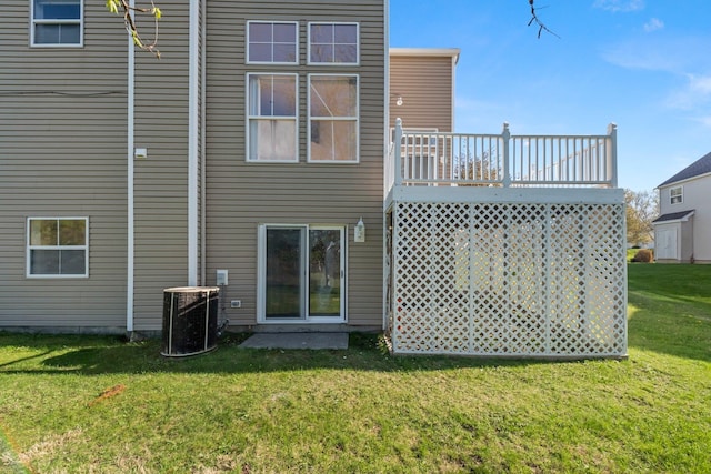 back of house featuring central air condition unit, a lawn, and a wooden deck