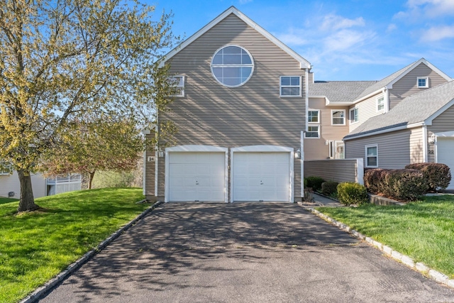 view of front of home featuring a garage, a front lawn, and driveway