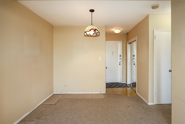 carpeted empty room featuring baseboards