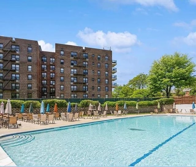 pool with a patio and fence
