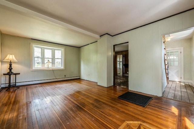 spare room featuring visible vents, a baseboard heating unit, and hardwood / wood-style floors