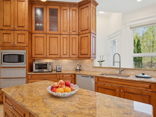kitchen featuring a sink, appliances with stainless steel finishes, a warming drawer, and brown cabinets
