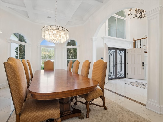 dining room with a towering ceiling, arched walkways, beamed ceiling, an inviting chandelier, and light tile patterned flooring