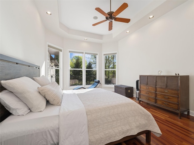 bedroom featuring recessed lighting, a tray ceiling, dark wood-style floors, and ceiling fan