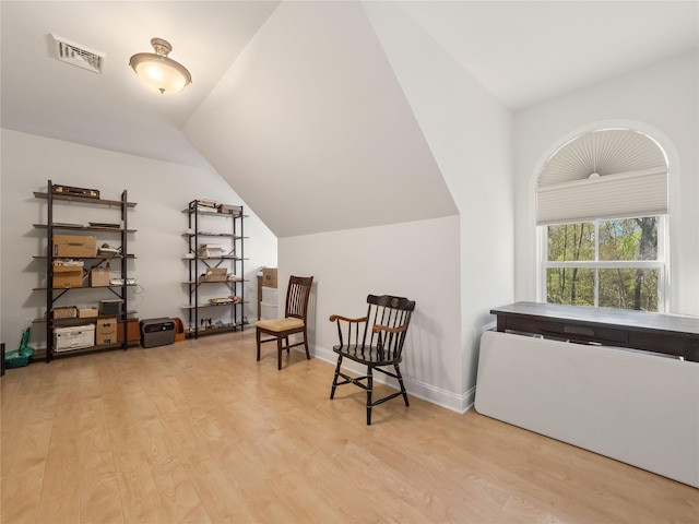 sitting room with visible vents, lofted ceiling, and light wood-type flooring