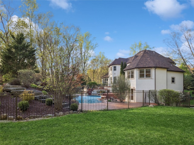 exterior space featuring stucco siding, roof with shingles, fence, and a yard