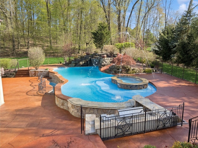 view of pool with a patio area, a pool with connected hot tub, and fence