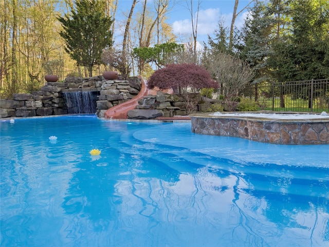 view of swimming pool with a fenced in pool, fence, and a water slide