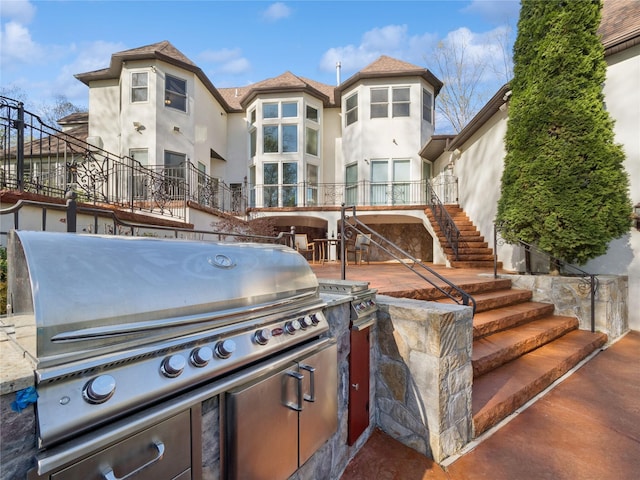 view of patio with stairs, an outdoor kitchen, and area for grilling