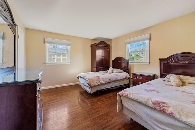 bedroom featuring baseboards, multiple windows, and dark wood-style flooring